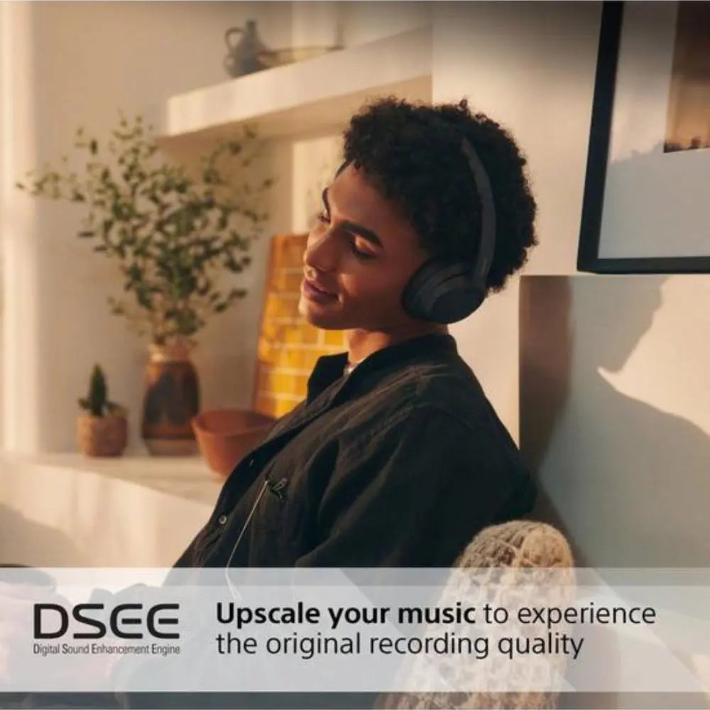 Wireless noise-cancelling over-ear Bluetooth headphones, dark finish, worn indoors