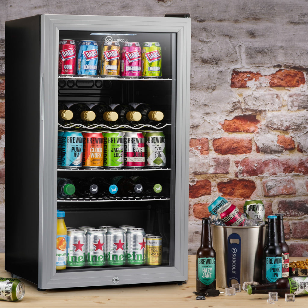 Silver LED beer fridge open with cans, bottles, and wire shelf rows