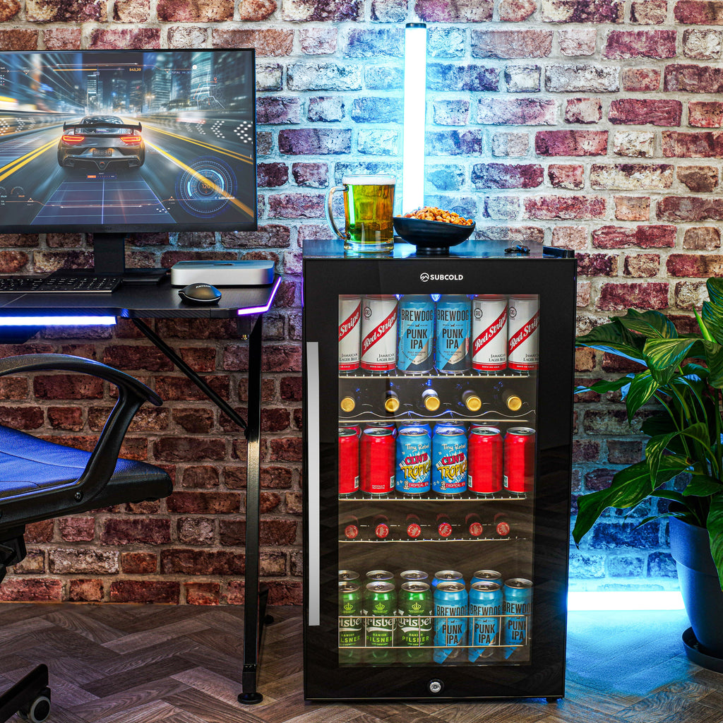 Freestanding black beer fridge with glass door, stocked with assorted cans on shelves