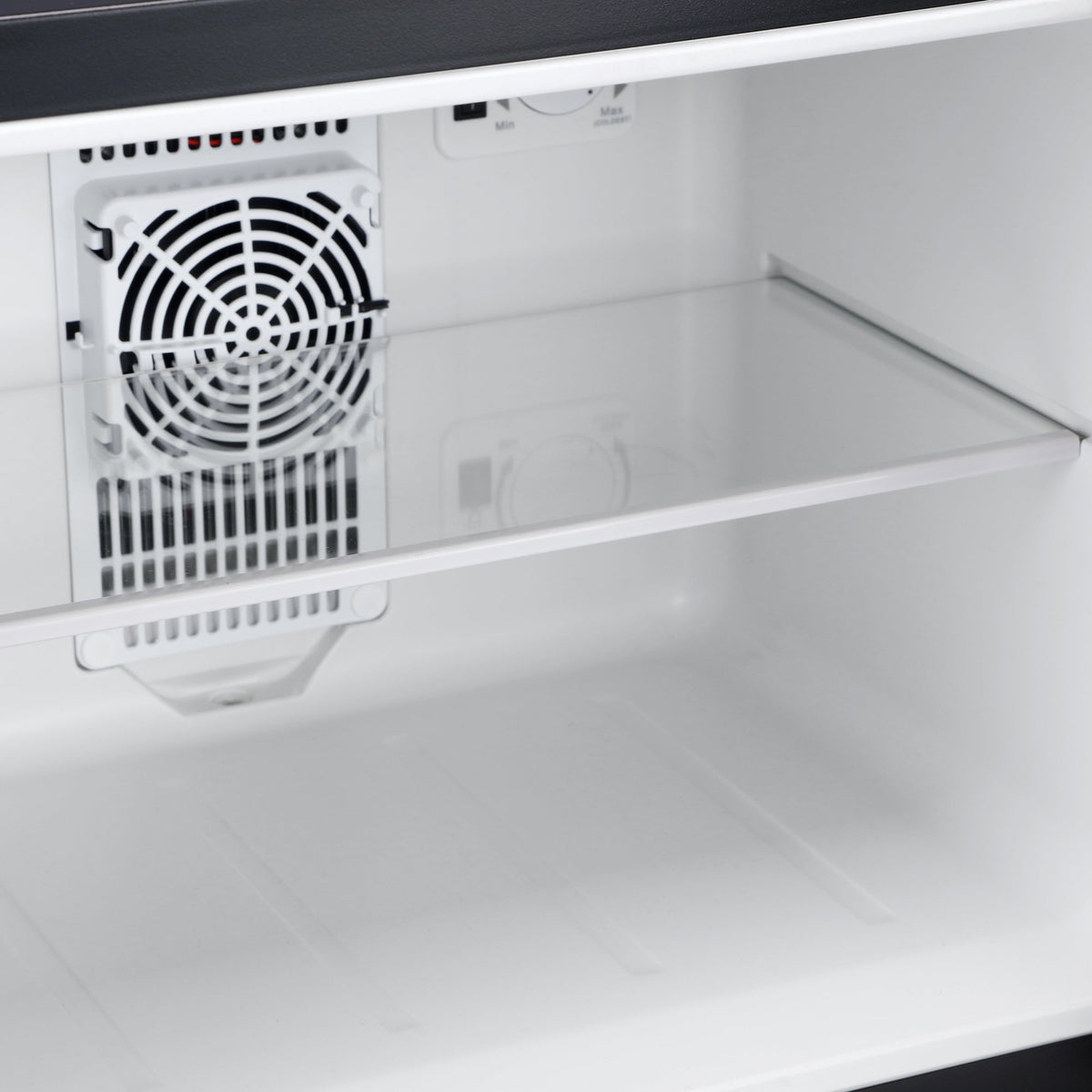 White mini refrigerator interior with cooling fan and vent grille at back