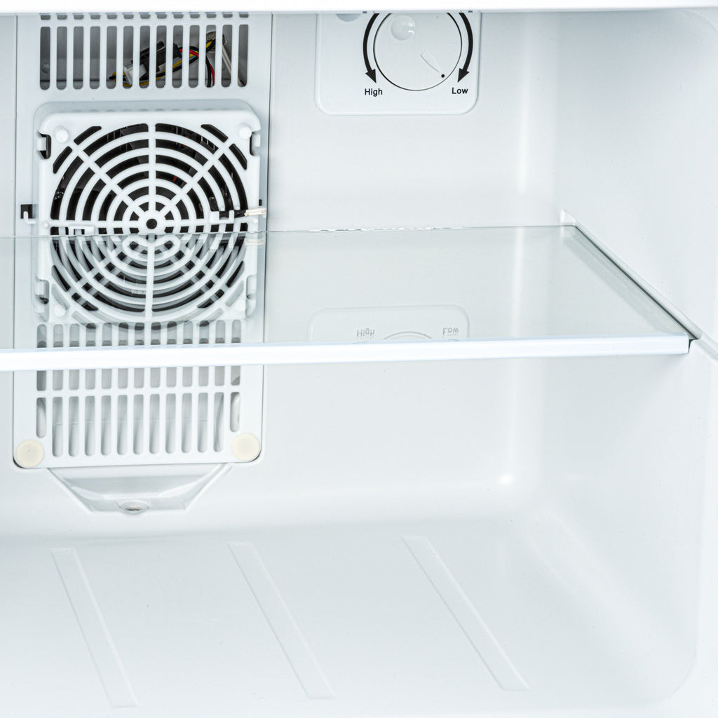Interior view of white mini fridge with fan grille and thermostat dial