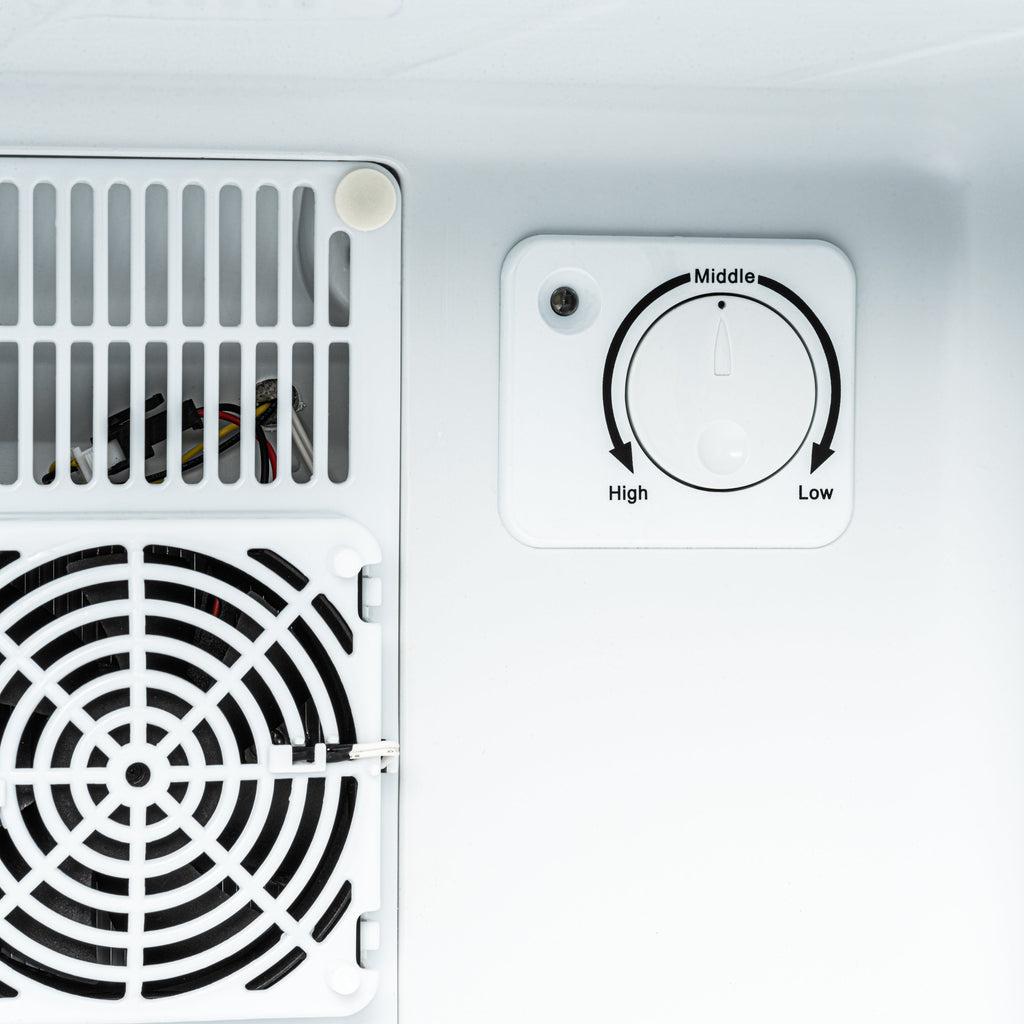 Mini fridge control dial marked High to Low and vent grille on left wall