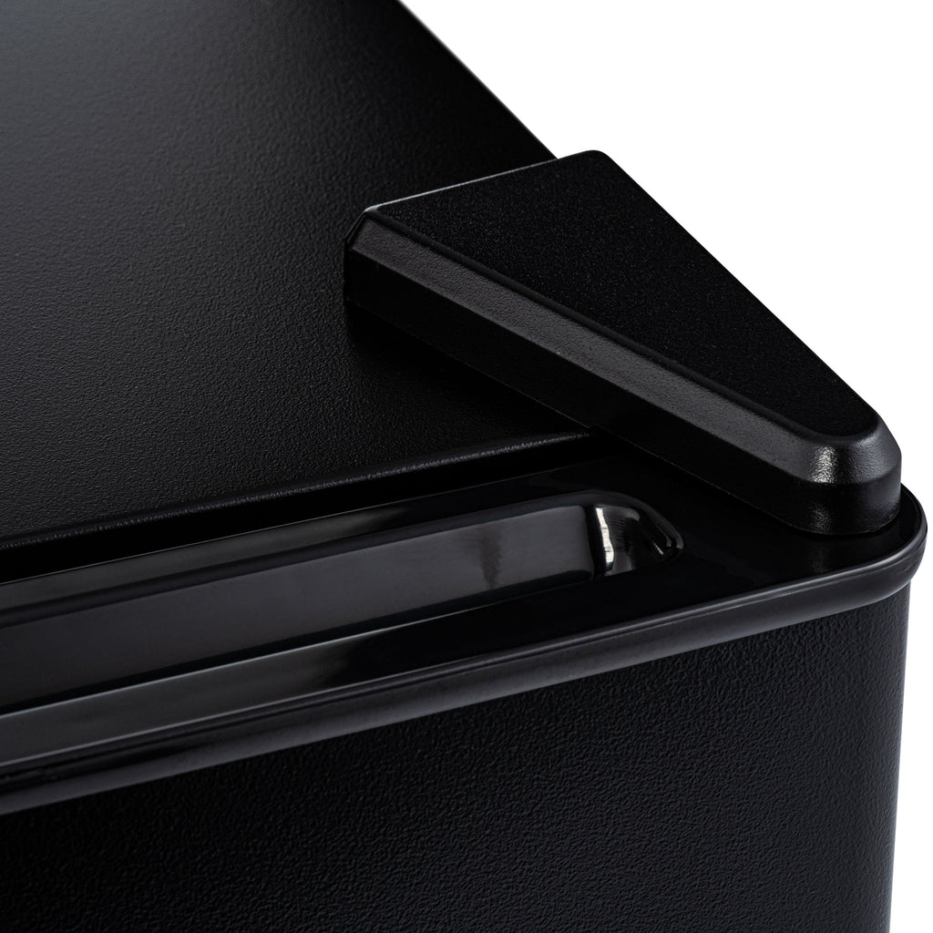 Mini fridge close-up of black side handle on textured black door