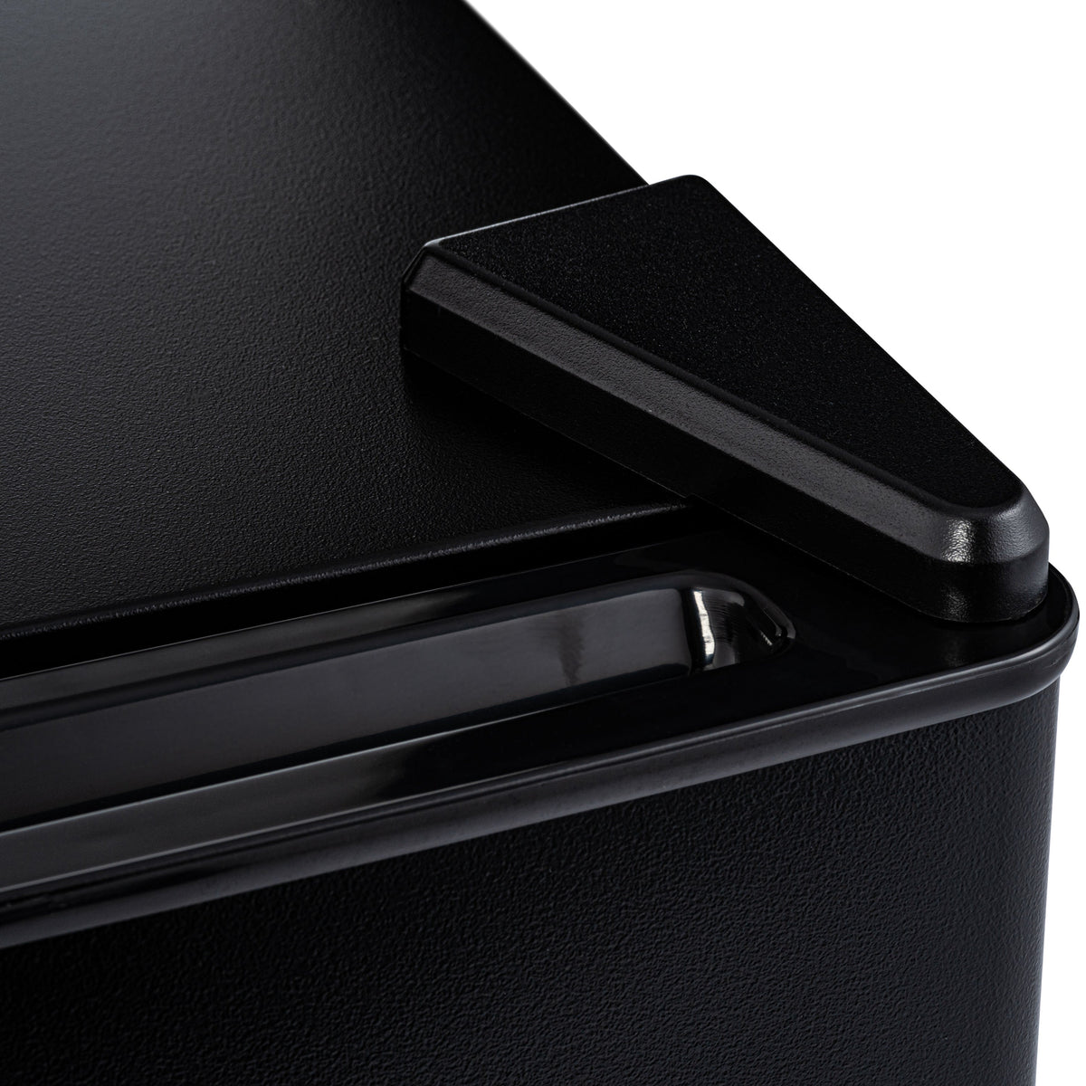 Mini fridge close-up of black side handle on textured black door