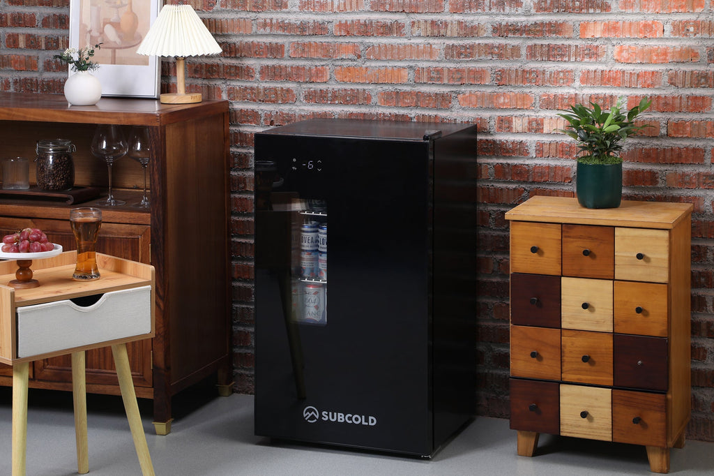 Black Subcold beer fridge standing on floor, front view with door closed