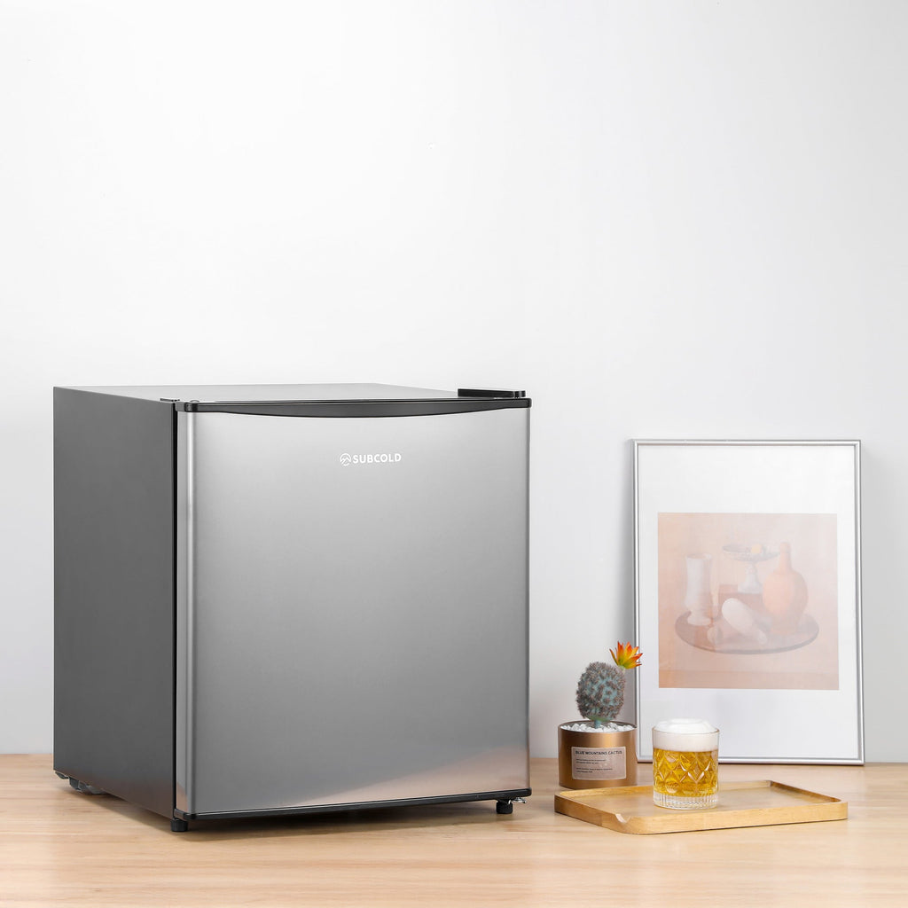 Stainless beer fridge with door closed on a wooden surface