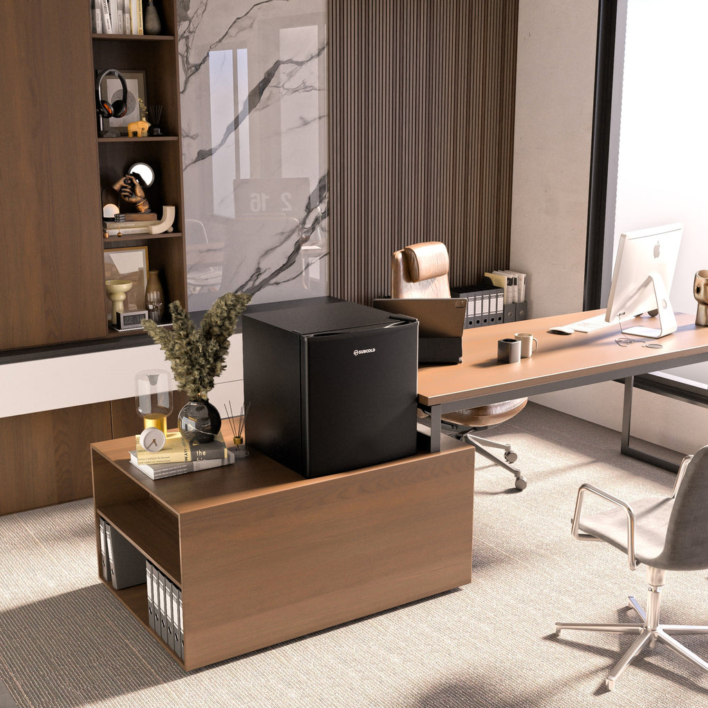 Black solid-door mini beer fridge on a wooden cabinet in an office setting