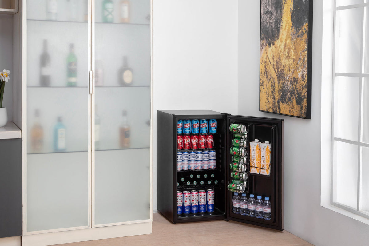 Black compact beer fridge with solid door open, stocked with drinks