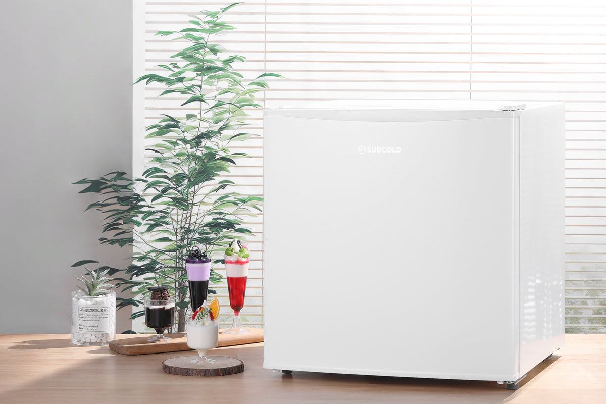 White compact mini freezer with closed door on legs, modern box design