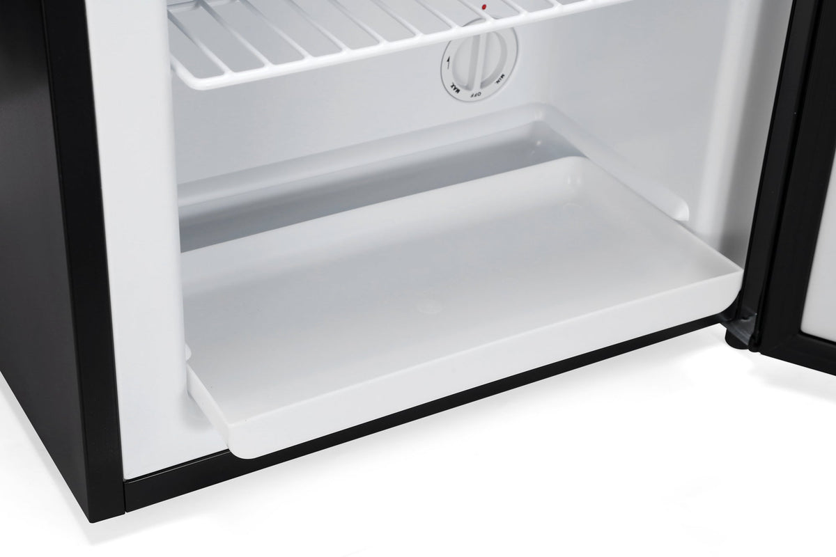 Mini freezer with open door, empty white lower tray, and round temperature control knob