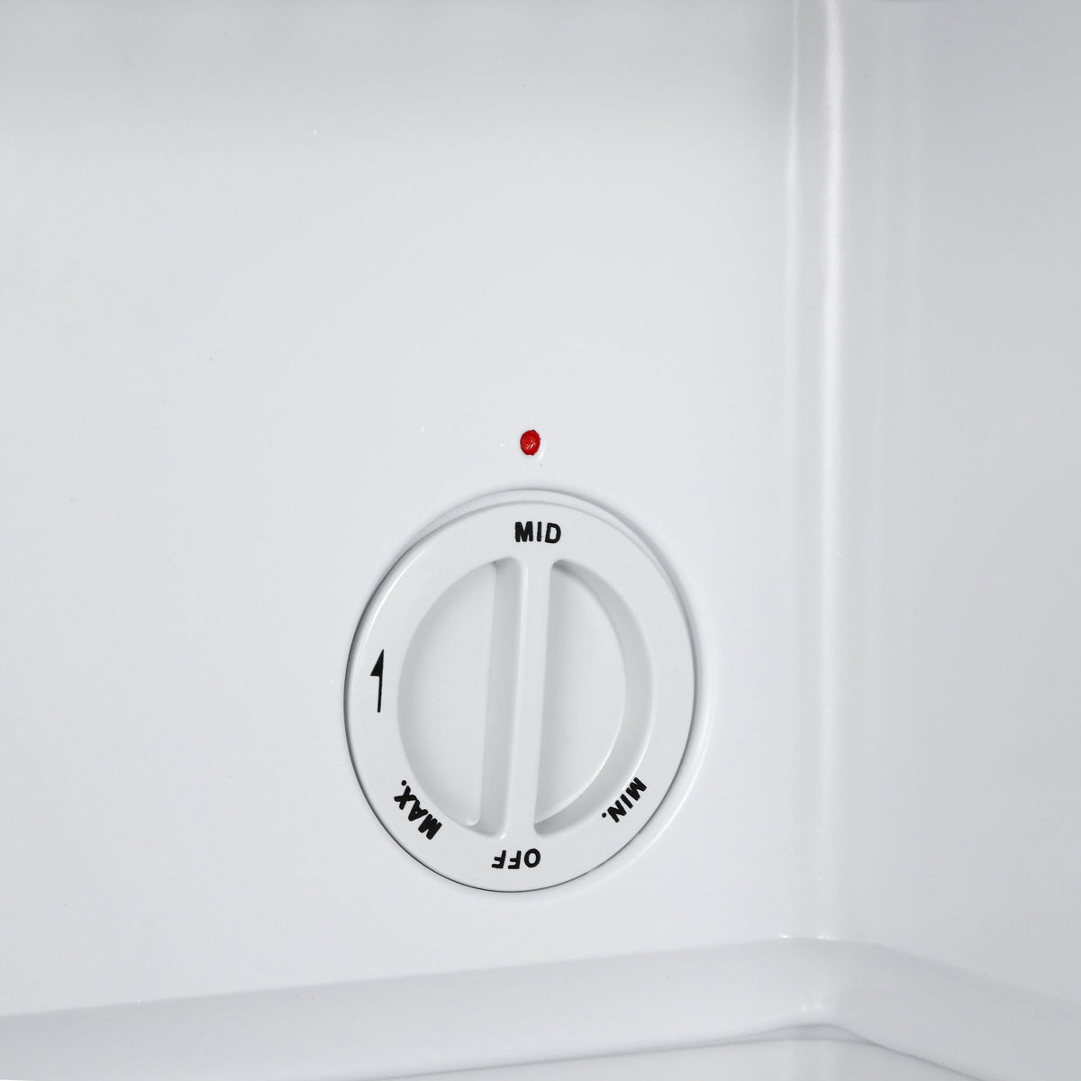 Mini freezer temperature dial with MID marking on the white interior wall