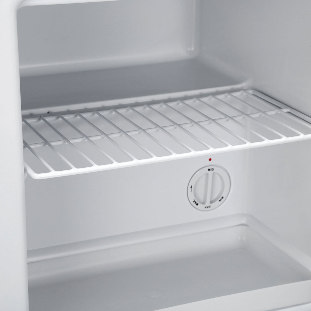 Mini freezer compartment with wire shelf, white interior, temperature control knob