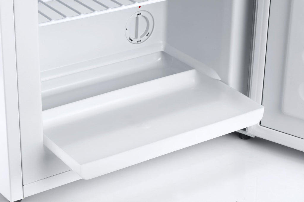 Open white mini freezer interior with shelf and temperature control dial