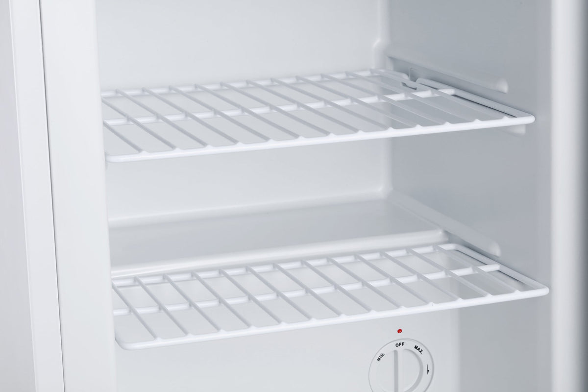 White mini freezer with wire shelves inside and temperature control knob