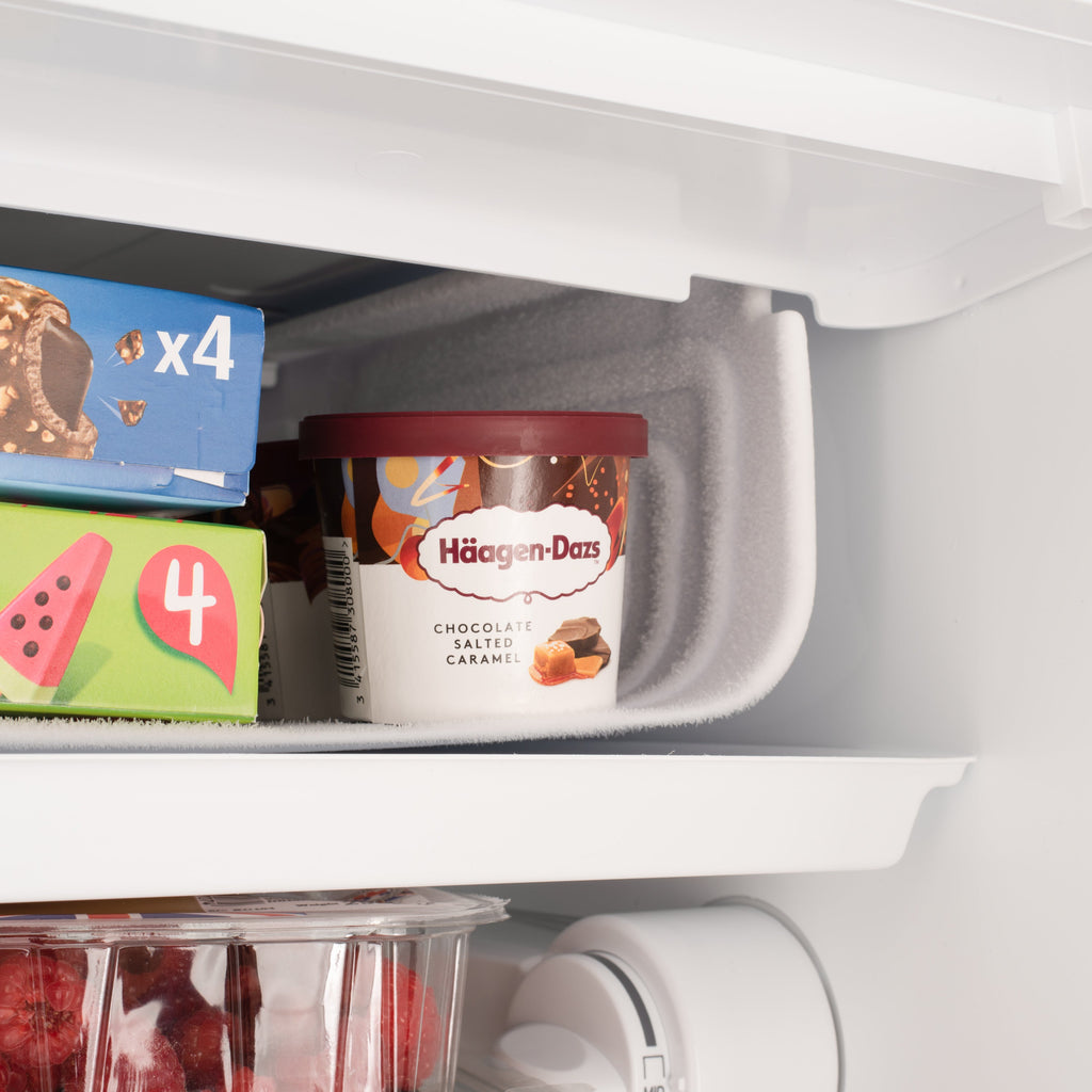 Under-counter fridge interior top shelf with packaged food items