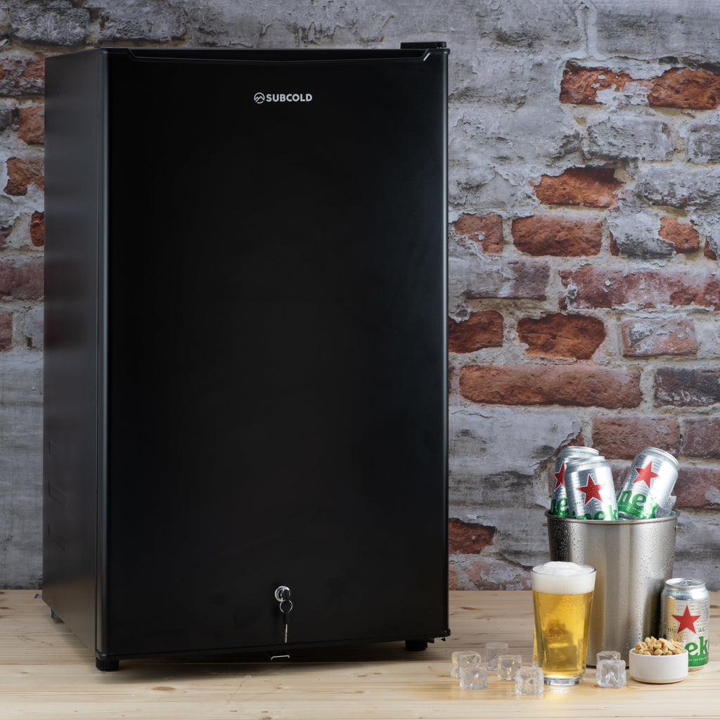 Black under-counter fridge standing with tap handle on front door
