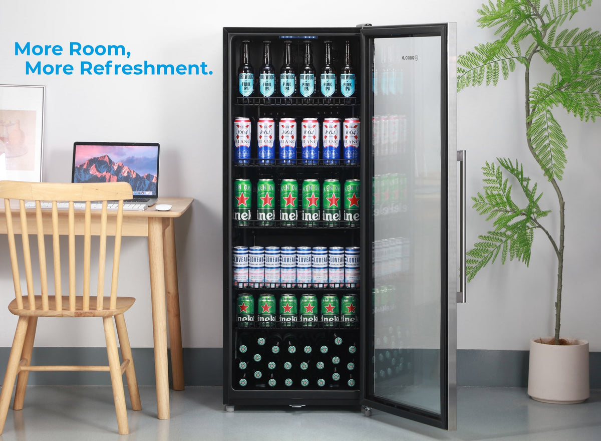 Tall stainless drinks fridge with open glass door, shelves holding cans and bottles