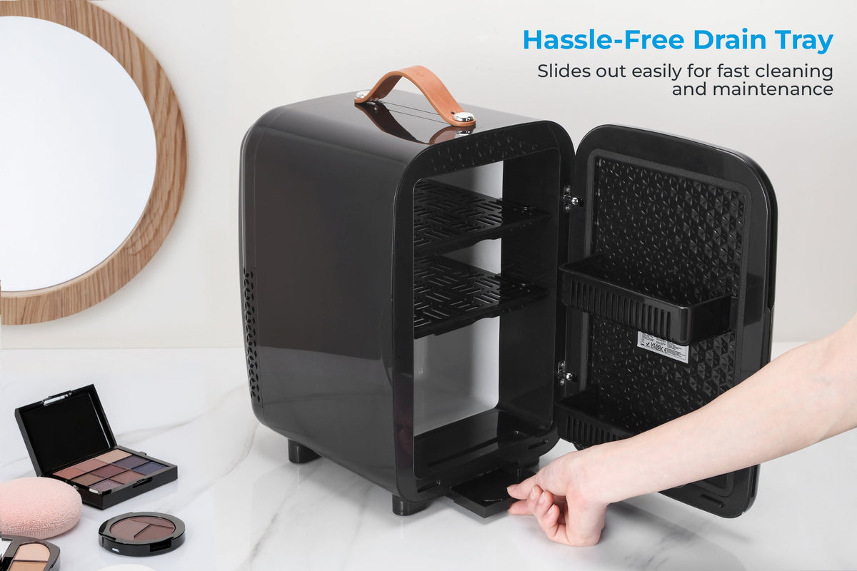 Black mini fridge with pull-out drain tray behind the open door
