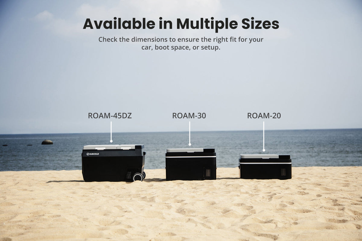Multiple black portable car fridges in a row on sandy beach