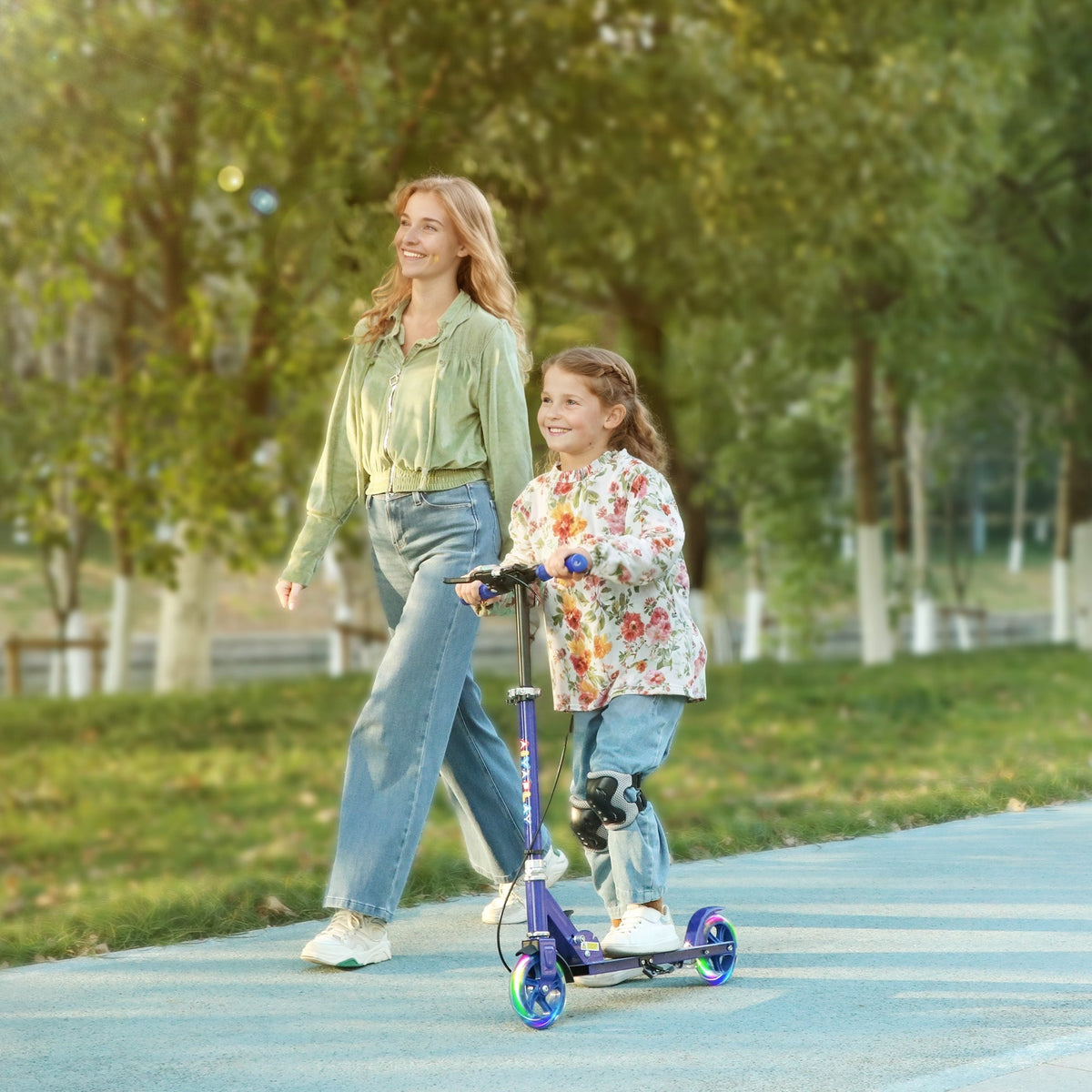 Kids folding kick scooter with blue frame and rainbow wheels being ridden