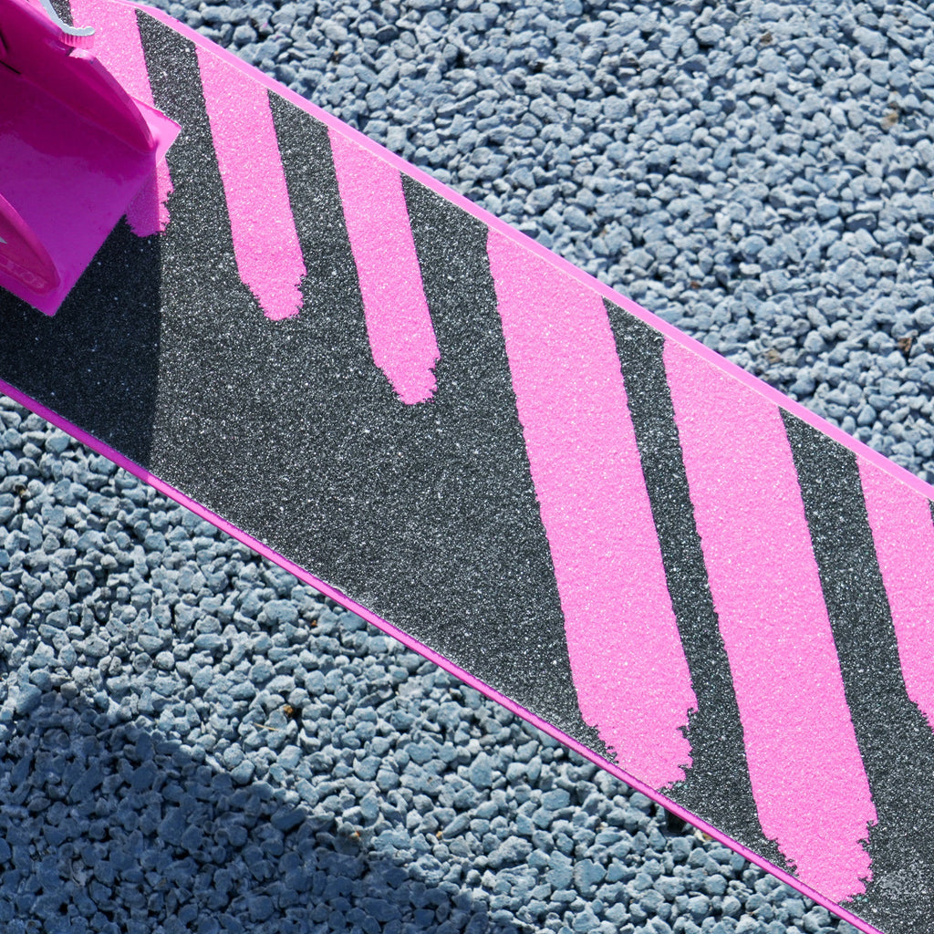 Kids folding kick scooter deck with non-slip pink stripe pattern, black grip surface