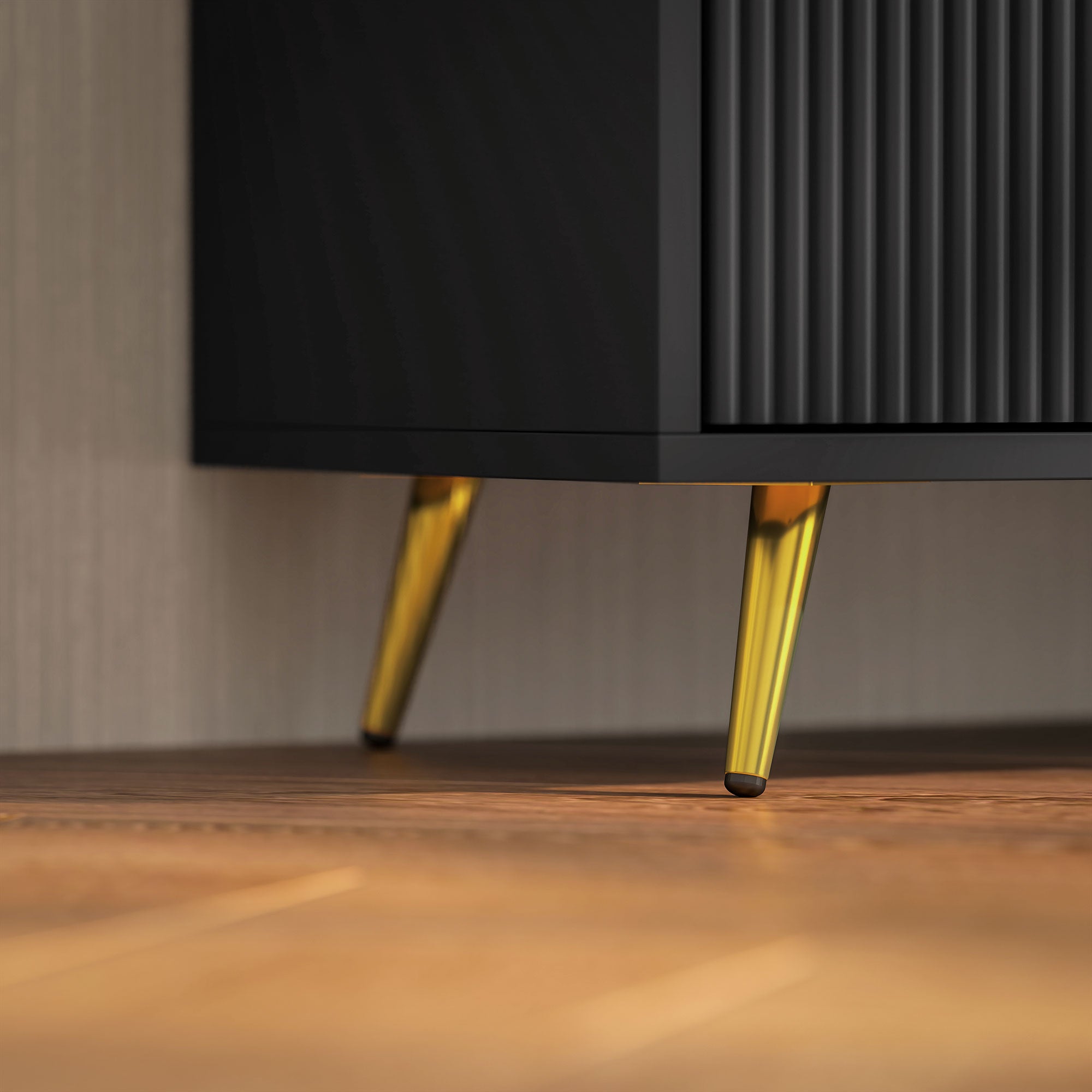 Black TV stand corner view with gold tapered legs and ribbed cabinet paneling