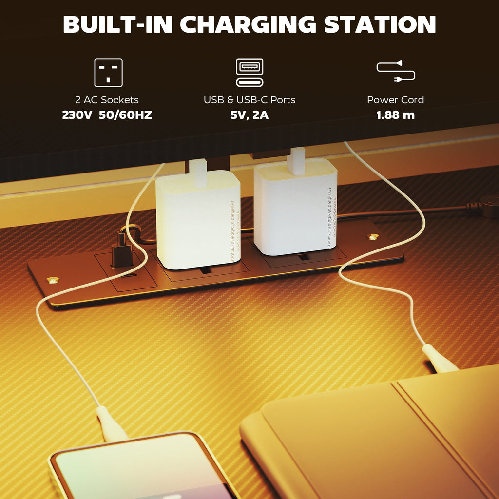 Black gaming desk with built-in charging station featuring AC sockets and USB ports