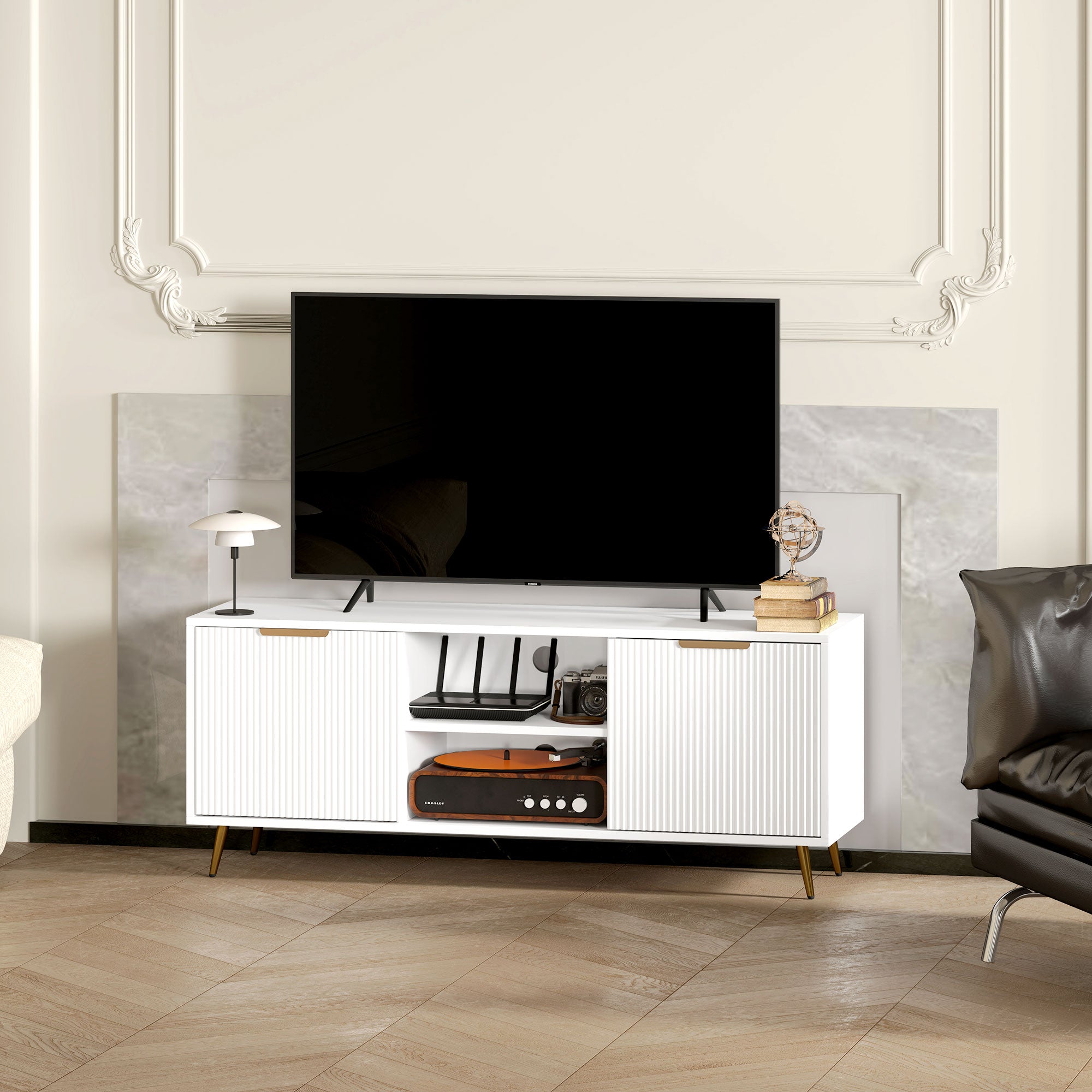 White TV stand cabinet with ribbed doors and open center shelf holding electronic devices