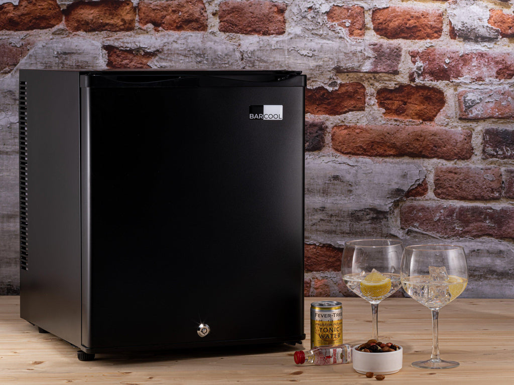 Black mini bar fridge with closed door and front corner view