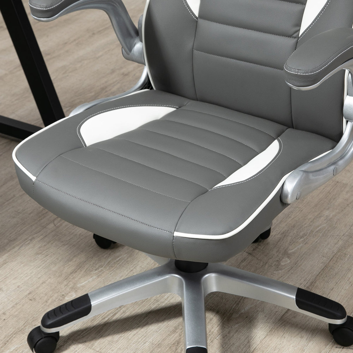 Grey padded seat with armrests on a five-wheel swivel base gaming chair with caster wheels