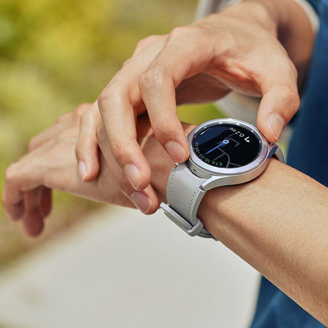 Round smartwatch with light-gray strap and dark display, worn on wrist