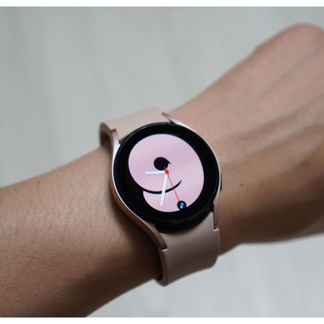 Smartwatch on wrist with light beige silicone band and round black display
