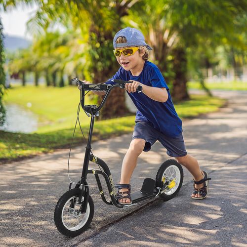 Black kids stunt scooter being ridden outdoors, with 12" rubber wheels and wide deck