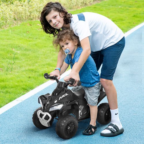 Kids foot-powered ride-on quad car with handlebars, used on a driveway