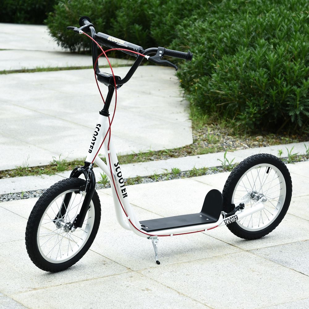 White kids kick scooter, side view with black deck, large rubber wheels, and kickstand