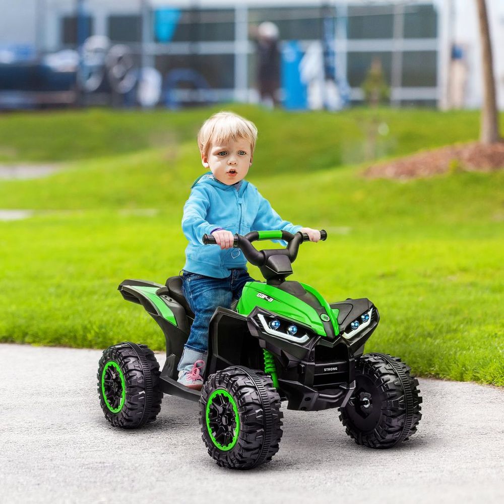 Green electric kids quad bike with black seat, four chunky wheels, and handlebar