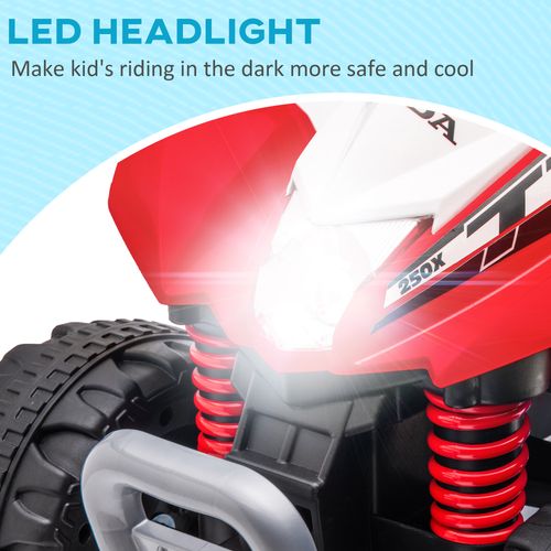 Red kids electric quad bike front with bright headlight and visible spring suspension