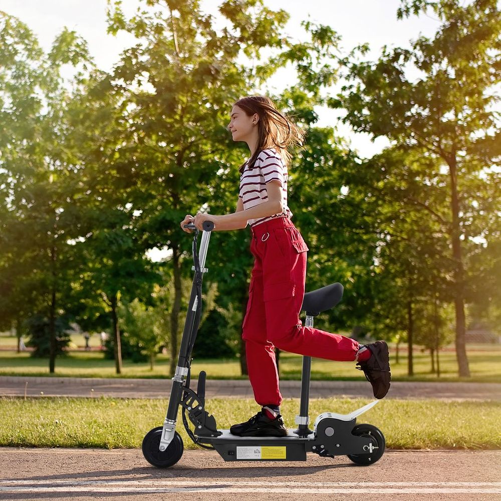 Black electric scooter with white deck and front wheel, shown being ridden by a teen