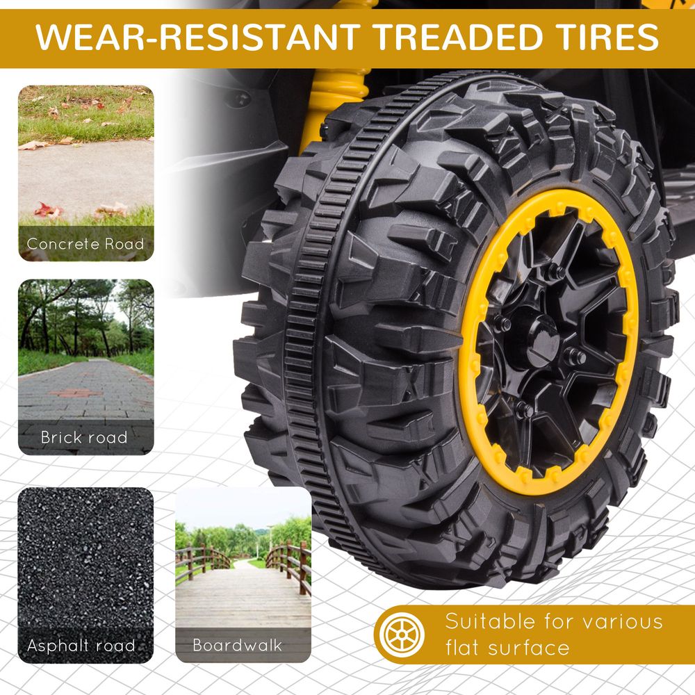 Close-up of yellow-rim tires on a black kids electric quad bike, treaded for grip