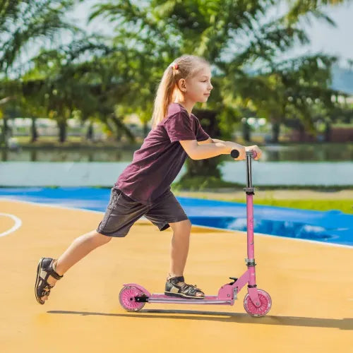 Kids pink scooter with LED wheels while a child rides outdoors