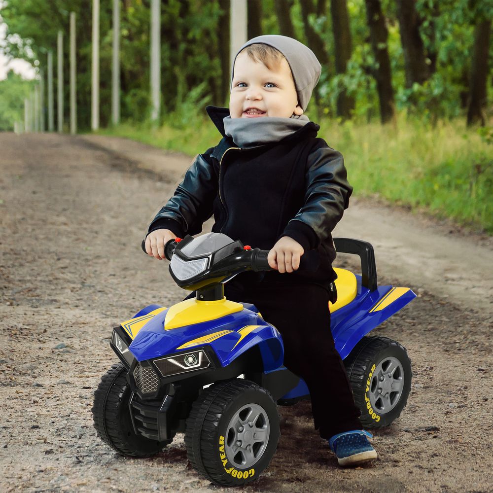 Quad bike ride-on with yellow seat and blue body, ridden by a toddler outdoors.