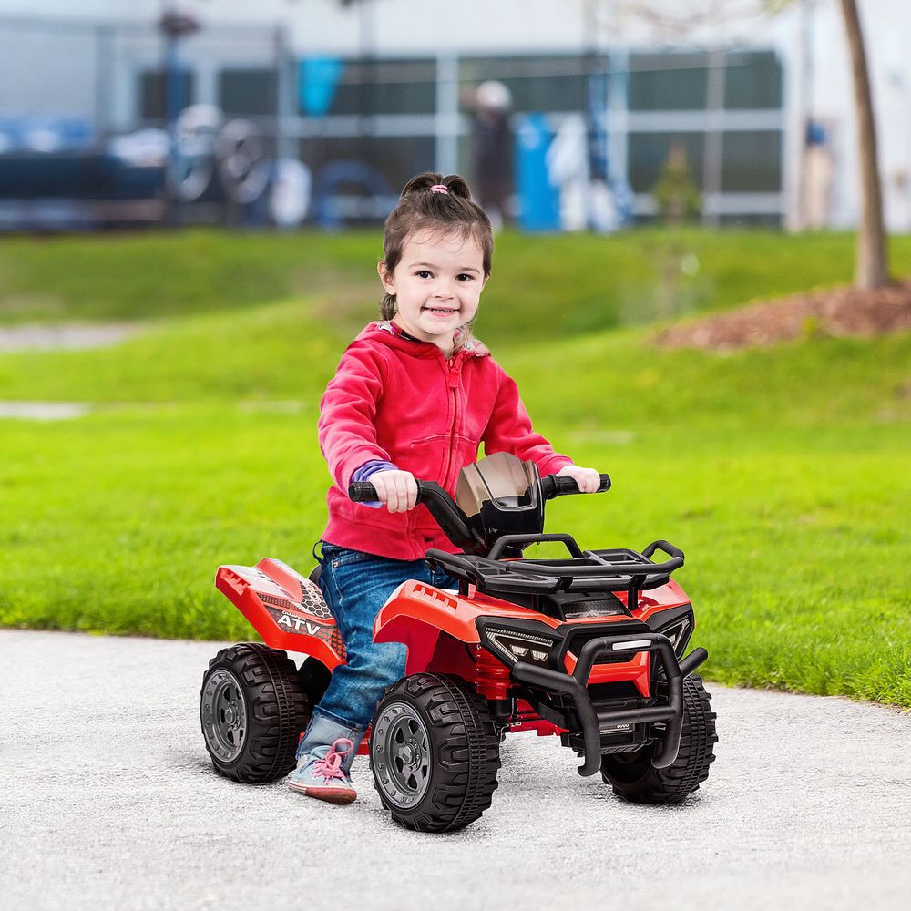 Red kids electric quad bike ridden by a child, with black wheels and bumper.
