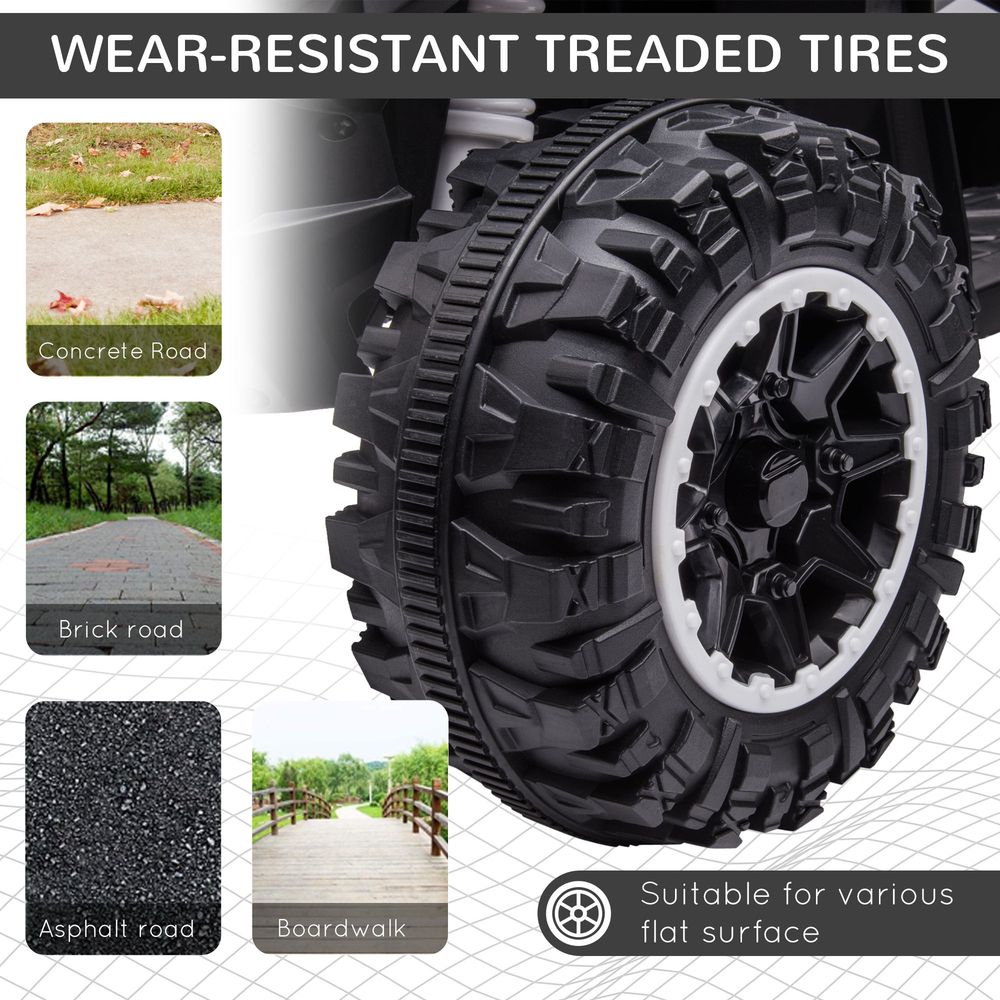 Close-up of large tread tires on a white and black kids electric quad bike