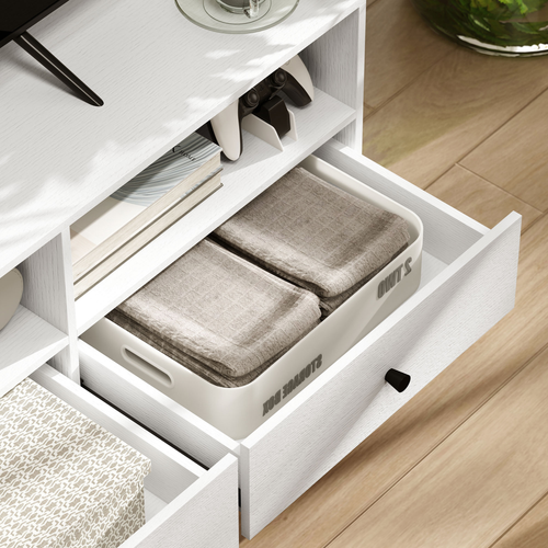 White TV cabinet drawer pulled out, showing folded linens and interior organizers