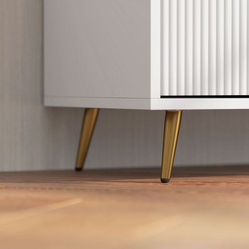 Bottom view of a white TV stand cabinet showing gold tapered legs on wood flooring