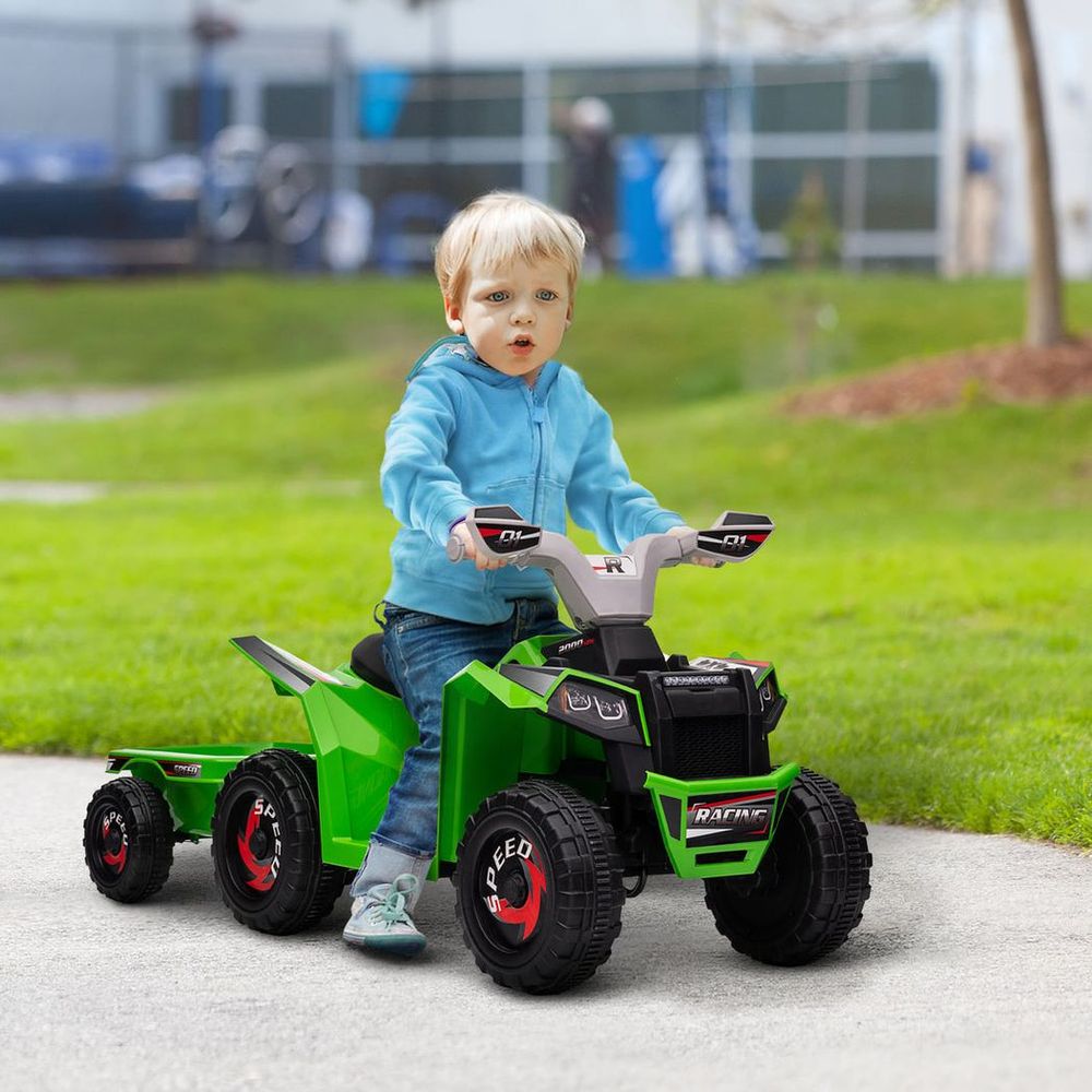 Kids riding electric quad bike, green body with black seat and four chunky tires