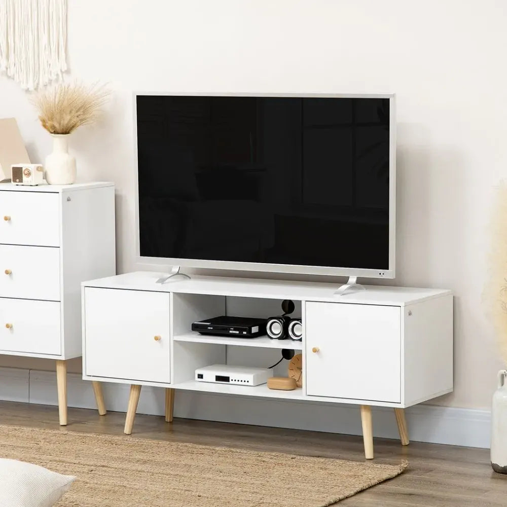 White TV stand with two drawers and side cabinets, holding media devices beneath a TV.