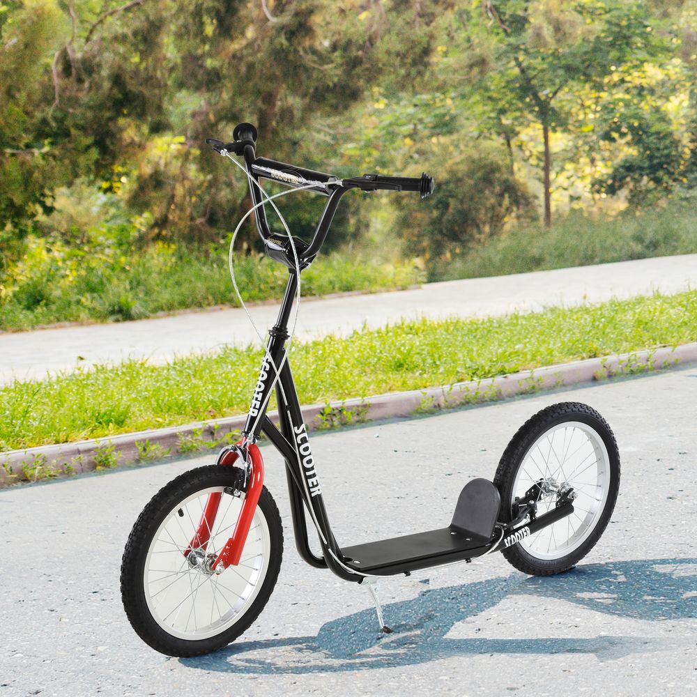 Kids kick scooter on path with black frame, red front fork, platform deck, large wheels