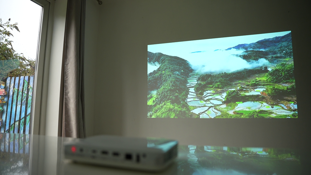 Ultra-portable smart projector projecting landscape video on a wall screen
