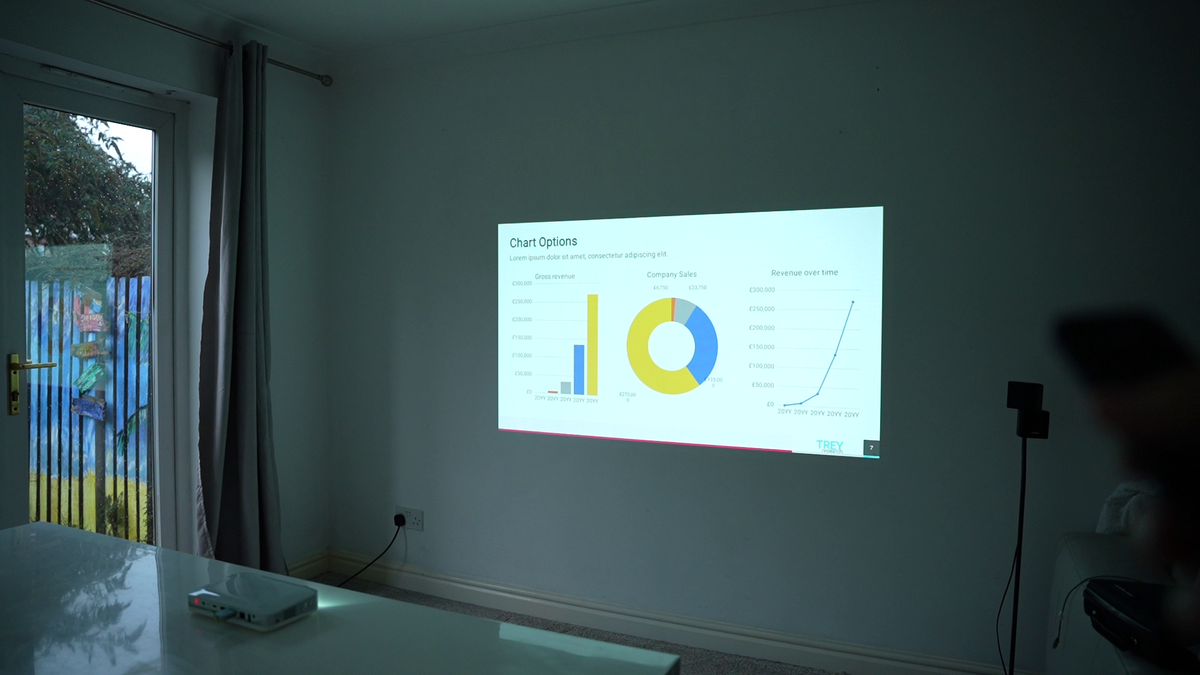 Ultra-portable smart projector projecting a chart slide on a wall screen